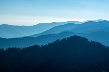 Fototapeta na wymiar Hazy Mountain Layers Under A Blue Sky