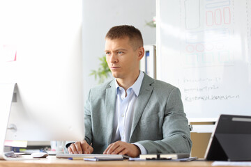 Fototapeta premium Portrait of caucasian business man working on laptop online in home office