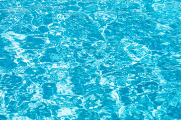 Water background, ripple waves. Blue swiming pool pattern. Sea surface. Water in swimming pool with sun reflection. Banner with copy space.