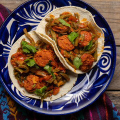 Mexican food. Chorizo and nopales tacos on wooden background