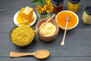 Fresh flower honey of different varieties, pollen and honeycomb with spoons on a wooden background. Organic Vitamin Health Food