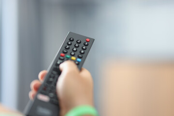 Watching TV and using the remote control closeup