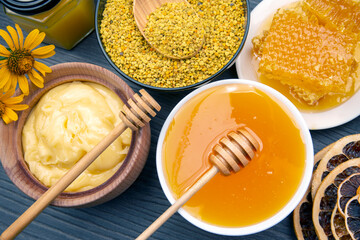 Fresh flower honey of different varieties, pollen and honeycomb with spoons on a wooden background. Organic Vitamin Health Food