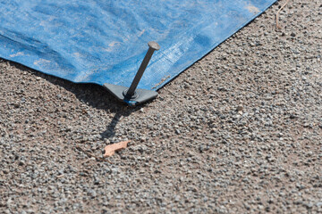 blue tarpaulin with anchor spikes covering the pitcher's mound