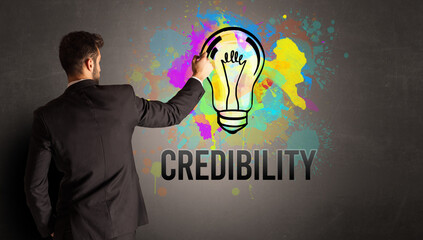 businessman drawing colorful light bulb