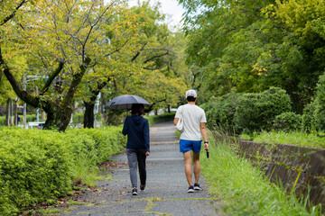 夏の公園でウォーキングしている男女の姿