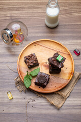 Chocolate Brownies with Fresh Milk and Candies photographed on wooden table