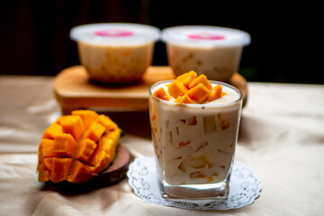 Mango Milk Cheese with a half of mango on white table with packaging for sale