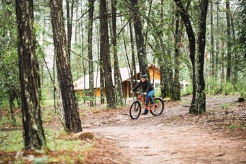 young latin man riding a bike in the mountain on vacation