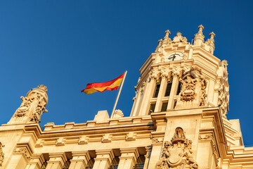 The flag of Spain fluttering on the Cybele Palace, Madrid