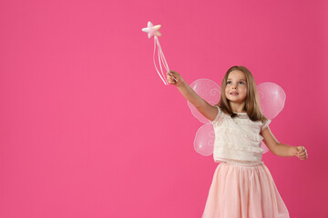 Cute little girl in fairy costume with wings and magic wand on pink background. Space for text
