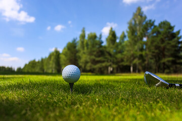Low section of man playing golf at driving range on a green field
