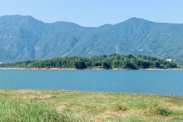 Fototapeta na wymiar Opposite the lake is a mountain and the shore is a grassland