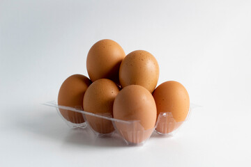 Some eggs and egg holder on white background