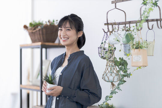 鉢植えを持つ若い日本人女性