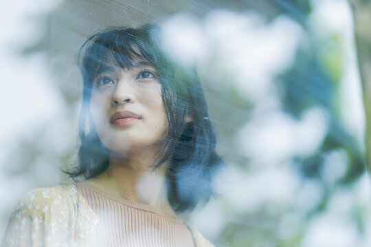 窓の外を眺める若い日本人女性