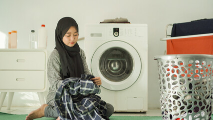 beautiful women in hijab will wash clothes at home