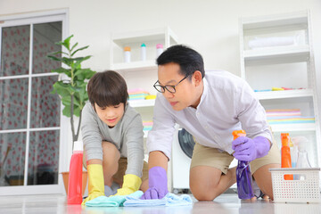 Asian father and son help each other to clean the floor for daily routine chores and housekeeping