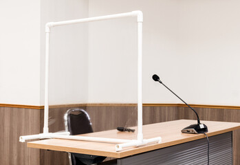 Conference table with clear plastic partition to prevent Covid-19