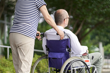 Fototapeta na wymiar 車椅子の高齢者をサポートする家族