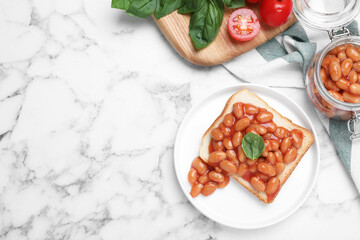 Toast with delicious canned beans on white marble table, flat lay. Space for text