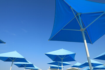 Bright beach umbrellas against blue sky on sunny day