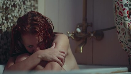 portrait of a scared girl with red hair in a bathroom with a police siren light effect. fear or domestic violence concept