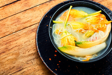 Vegan noodle soup with zucchini flowers