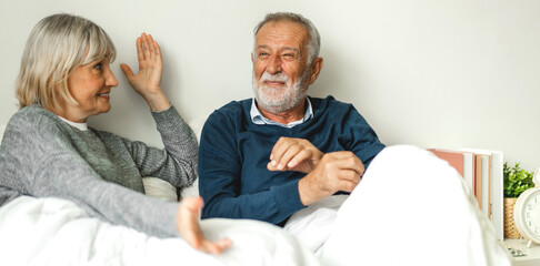 Senior happy love elder couple relaxing and talking together lying on bed in bedroom at home.Retirement healthcare couple concept