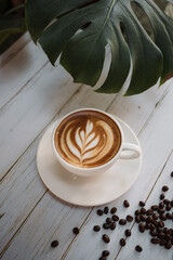 Latte art coffee on wooden table in coffee shop