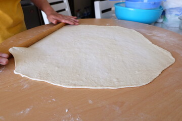 Process of making a traditional Turkish dough is called "Borek", selective focus. It is called "Kol Boregi" in Turkish. Round pie with cheese, spinach, greased with yolk. Delicious Balkan pie.