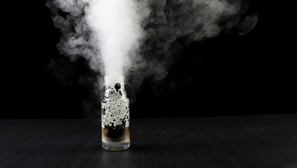 Potassium Permanganate Hydrogen Peroxide Decomposition Reaction. Smoke effect from the chemical reaction of mixing KMno4 and H2O2. Dangerous experiment on black background.