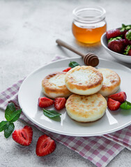Cottage cheese pancakes, ricotta fritters on ceramic plate with  fresh strawberry.