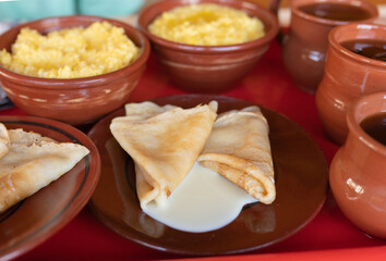 Traditional Russian breakfast of thin pancakes, pumpkin millet porridge and herbal tea