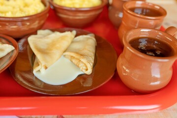 Traditional Russian breakfast of thin pancakes, pumpkin millet porridge and herbal tea