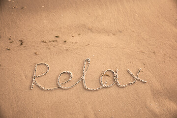Fototapeta na wymiar Sandy beach with written word Relax in summer, above view