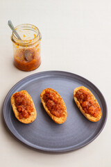 Cardamom rusks with cloudberry jam on gray plate 