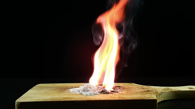 Experiment using Potassium permanganate KMnO4 and Sugar. Potassium permanganate and sugar can start a fire. Image on black background