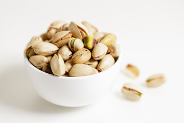 bowl with pistachios on white background