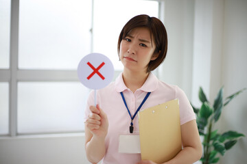 ×札を持つ介護士