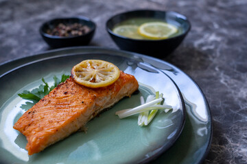 Side view of Salmon fish fillet cooked with different spices and served on plate.