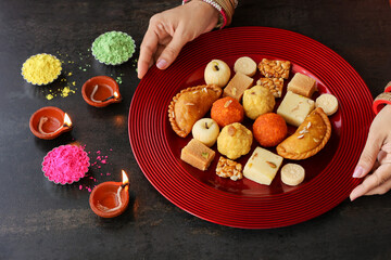Indian woman serve Diwali sweets Gujiya peda barfi Indian Sweet dessert mithai festival dish Dussehra Holi ganesh chaturthi Ram navami Durga pooja, durga ashtami Navratri Mumbai Kerala India Sri Lanka