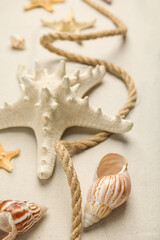 Fototapeta na wymiar Beautiful sea stars, shells and rope on sand, closeup