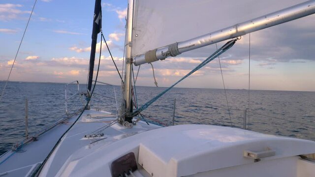 yachting at sea at sunset, ship's bow point of view, sailing in open sea