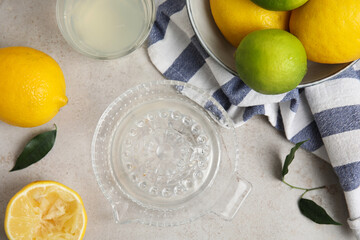 Glass squeezer with juice and lemons on light table, flat lay