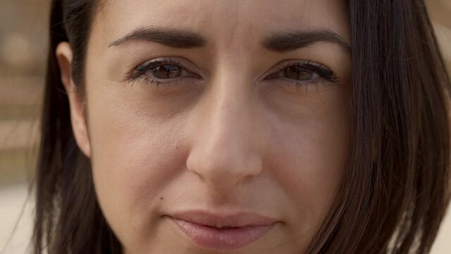 Outdoor portrait of a Hispanic woman looking at the camera with a serious face. Close-up of a serious female face. Concept of people and emotions.