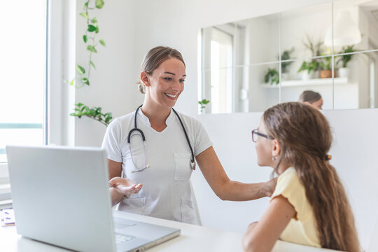 Shot Of A Doctor Having A Consultation With A Little Girl In Her Consulting Room. 7 Year Old Female Patient Speaking With Her Paediatrician In A Doctors Office