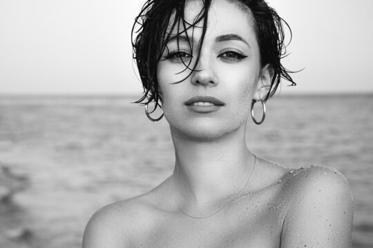 Black and white portrait of a beautiful girl on the beach. Outdoor shot. Summer vacation concept.