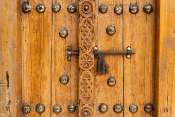 Fototapeta premium An old wooden door with metallic latch, closed, close up, Unaited Arab Emirates