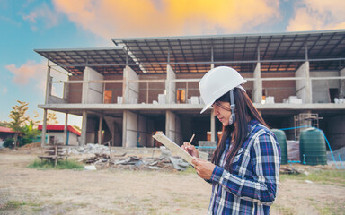 Woman construction engineer hold blueprint wear plaid shirt safety white hard hat at construction site industry labor worker. Architecture Female engineer civil worker look at blueprint real estate
